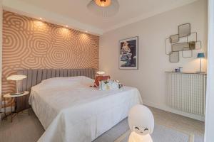 sypialnia z białym łóżkiem z malowidłem pająka w obiekcie Superbe appart VUE MER, PLAGE, PISCINE, TENNIS, parking w mieście Antibes