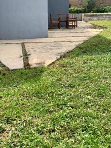 a bench sitting next to a field of grass at The GA Apartment in Abeokuta