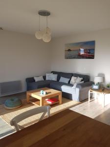 a living room with a couch and a table at Au cœur du Bassin d'Arcachon in Gujan-Mestras
