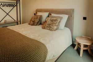 ein Schlafzimmer mit einem großen Bett mit Kissen darauf in der Unterkunft Luxe schuurwoning 't Nieuwt in Chaam, Nederland in Chaam
