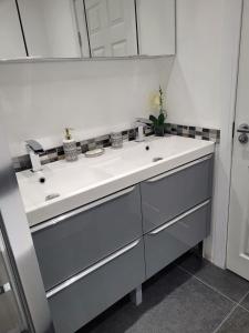 ein weißes Badezimmer mit einem Waschbecken und einem Spiegel in der Unterkunft La Casa Bella in Sheffield