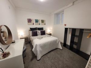 - une chambre blanche avec un lit et un miroir dans l'établissement La Casa Bella, à Sheffield