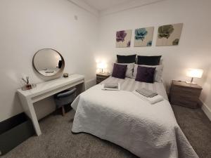 1 dormitorio con cama con espejo y escritorio en La Casa Bella en Sheffield