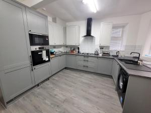 a kitchen with white cabinets and a washer and dryer at La Casa Bella in Sheffield