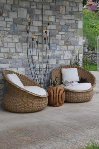 two wicker chairs sitting in front of a brick wall at MiTerra Cozy Apartments in Andritsaina