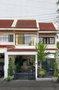 uma casa com um telhado vermelho e um edifício em Napshot Guesthouse em Banguecoque