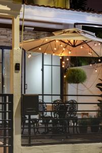 a bench under an umbrella on a porch with lights at Napshot Guesthouse in Bangkok