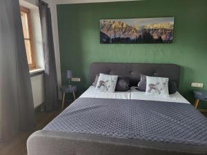 a bedroom with a bed with a green wall at Ferienwohnungen beim Silbergersee in Oberaudorf