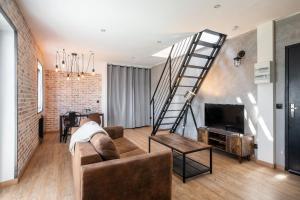 ein Wohnzimmer mit einer Treppe und einer Couch in der Unterkunft Superbe Loft industriel - Casa Vostra - Gaillard Tram-Frontière in Gaillard