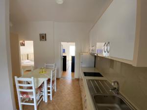 a kitchen with a table and chairs and a kitchen with a sink at Wave n' Sea Apartments in Himare