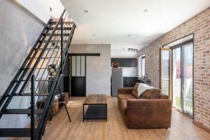 ein Wohnzimmer mit einer Treppe und einer Ziegelwand in der Unterkunft Superbe Loft industriel - Casa Vostra - Gaillard Tram-Frontière in Gaillard