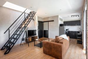 ein Wohnzimmer mit einem Sofa und einer Treppe in der Unterkunft Superbe Loft industriel - Casa Vostra - Gaillard Tram-Frontière in Gaillard