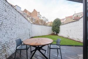einen Tisch und Stühle auf einer Terrasse mit Ziegelwand in der Unterkunft BRICKLANE FLATS in Brüssel