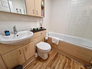 a bathroom with a sink and a toilet and a tub at Stunning Luxury Serviced Apartment next to City Centre with Free Parking - Contractors & Relocators in Coventry