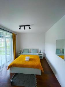 1 dormitorio con 1 cama grande con manta amarilla en Pensiunea Freya, en Colibiţa