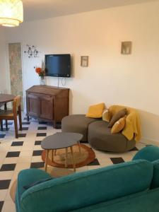 a living room with a couch and a tv at Rue des roses in Saint-Pierre-dʼOléron