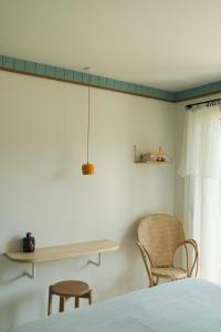 a bedroom with a bed and a table and two chairs at Hotel des Dunes in Cap-Ferret