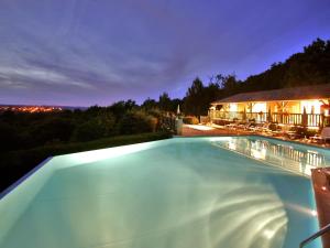 - une piscine avec une maison la nuit dans l'établissement Les Ventoulines, à Domme