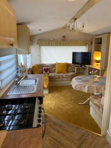 a kitchen and living room with a couch and a table at Annie’s Corner in Ingoldmells