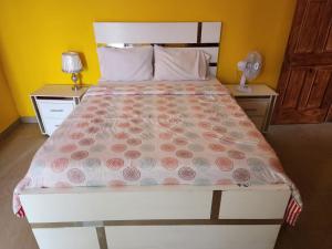 a bedroom with a large bed with pink flowers on it at Super Two Bedroom Penthouse in Peguy-Ville 