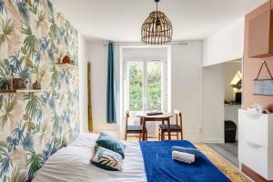 1 dormitorio con 1 cama con manta azul en Friendly Studio Orsay - Near Schools & Businesses, en Orsay