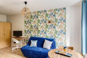 sala de estar con sofá azul y mesa en Friendly Studio Orsay - Near Schools & Businesses, en Orsay