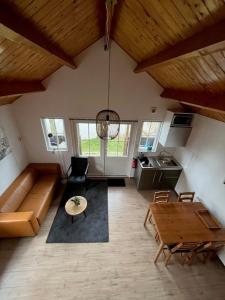 a living room with a couch and a table at Vakantiehuisjes Marsherne in Poppingawier