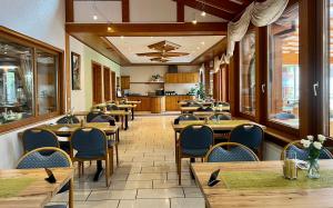 a restaurant with wooden tables and chairs and a kitchen at Hotel Klosterbräustuben in Zell am Harmersbach