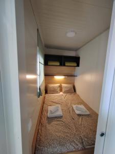 a small bed in a small room with two towels on it at Mobile Homes "Golden Stone" in Sveti Juraj
