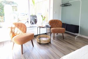 a living room with two chairs and a table at Huisje Sasa in Hierden