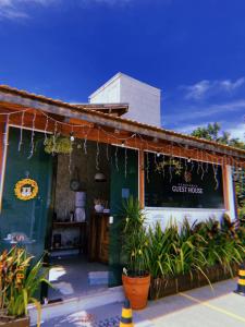 a restaurant with plants in front of a building at Bombinhas Guest House in Bombinhas