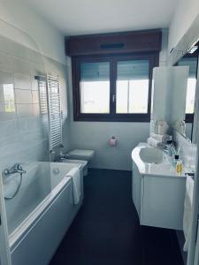 La salle de bains est pourvue d'une baignoire, d'un lavabo et d'une baignoire. dans l'établissement Home sweet home Rho Fiera, à Pero