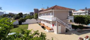 a large white building with a balcony and a yard at Ragias Studios in Tsilivi