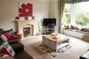 a living room with a couch and a fireplace at Comfy big 7 bedroom townhouse in Harrogate