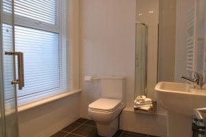 a white bathroom with a toilet and a sink at Comfy big 7 bedroom townhouse in Harrogate