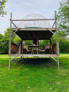 a gazebo with chairs and a table in the grass at Bulle Elevage Girbal in La Chapelotte