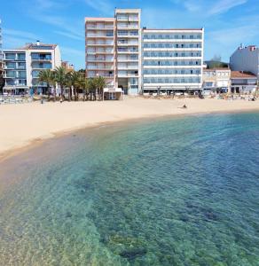 vistas a una playa con edificios y al océano en Hotel Rosamar en Sant Antoni de Calonge