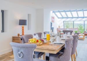 a dining room with a wooden table and chairs at USK Barn in Llanbadoc