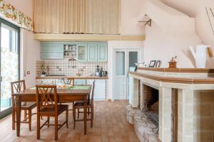 a kitchen with a table and a fireplace at B&B Vigna del Duca in Grassano