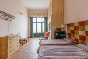 1 dormitorio con 2 camas, vestidor y ventana en B&B Vigna del Duca en Grassano