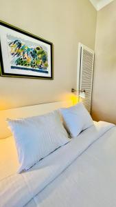 a bedroom with a white bed with a picture on the wall at Apartment Marta in Preko