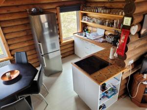 a kitchen in a log cabin with a refrigerator and a table at Akureyri Log Cabin in Akureyri