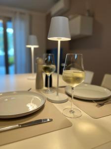 Vista mare Grado في غرادو: طاولة مع كأسين من النبيذ الأبيض عليها