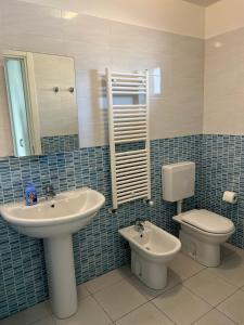 Vista mare Grado في غرادو: حمام مع حوض ومرحاض ومرآة