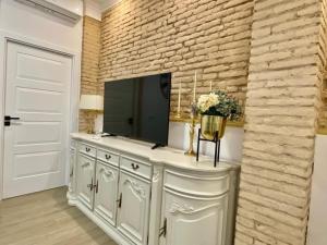 a living room with a television and a brick wall at Marin Beach Apartment Malvarrosa in Valencia