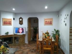 ein Wohnzimmer mit einem TV und einem Kamin in der Unterkunft El Capricho de Mamá - Chalet con piscina in Barbate