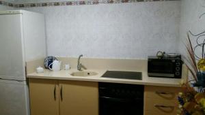 Una pequeña cocina con fregadero y microondas. en El Capricho de Mamá - Villa con piscina, en Barbate