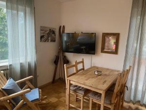 a dining room with a wooden table and a television at Apartment Skischanze in Garmisch-Partenkirchen