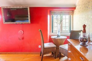 comedor con paredes rojas, mesa y sillas en B&B Quarto Vermelho Estilo Moderno, 