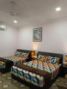 una camera con due letti e un divano di Alfa Roomstay a Pantai Cenang